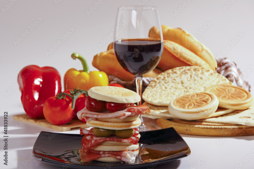 Foto Stock pane,tigelle e piadina, vino rosso e salumi | Adobe Stock
