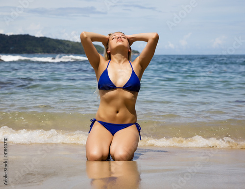 Beautiful girl sunbathes on a beach in Thailand