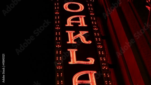 Medium shot of  Downtown Oakland sign in red neon