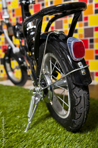 black small bicycle isolated on colorful background