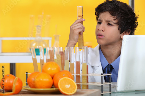 Boy analysing orange juice