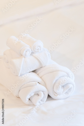 Obraz na płótnie bath towels rolled on white bed w salonie