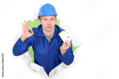 Tableau sur toile Tradesman giving the a-ok sign and holding up cards