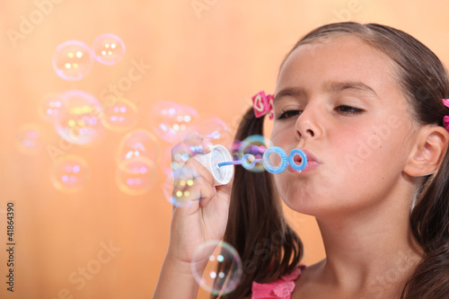 Young girl blowing bubbles