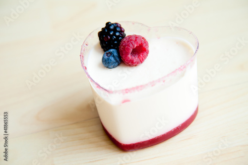 Panna Cotta in heart shape cup on wood pattern background :