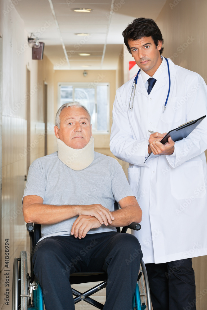 Fototapeta premium Doctor Standing By Patient On Wheel Chair