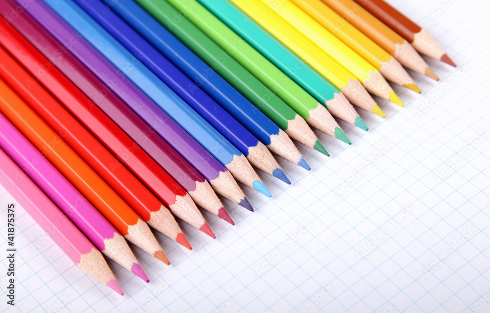 Multicolored crayons on white squared paper background. Multicolored crayons on white squared paper background.