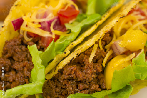Close up of Mexican minced beef tacos with salsa and cheese.