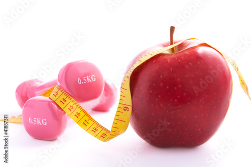 Apple and dumbbells tied with a measuring tape.