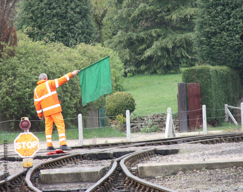 A Railway Worker Signalling a Train with a Green Flag. photo