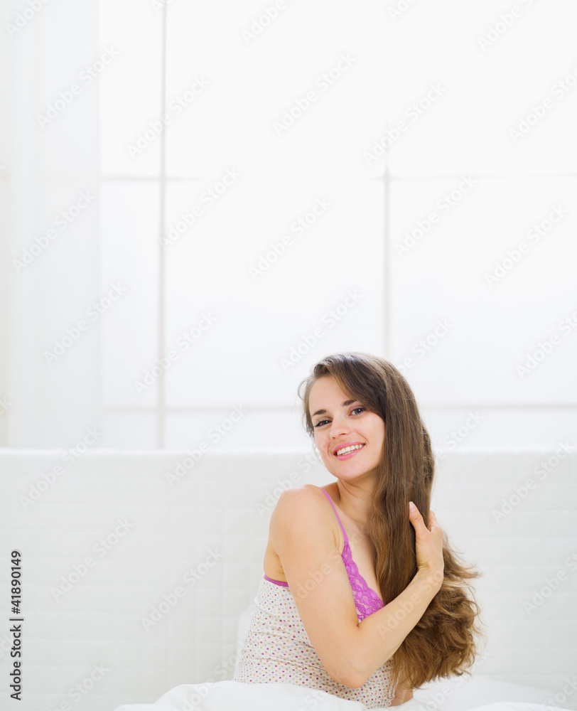 Happy beautiful long hair woman sitting in bed Happy beautiful long hair woman sitting in bed