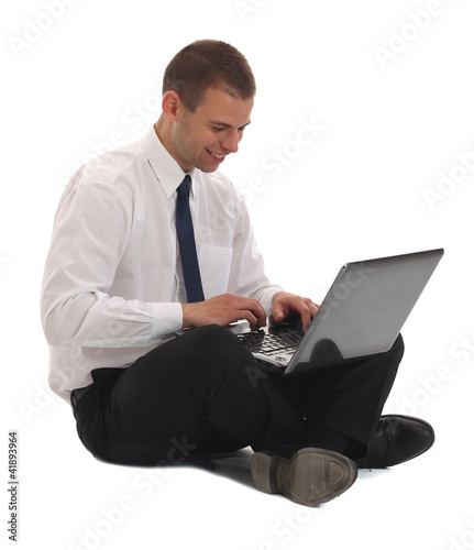 Happy young business man working on a laptop
