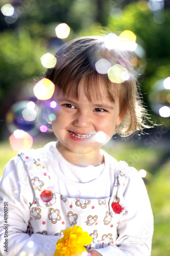 Small girl with a flower and soap bubbles photo