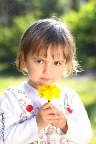 Little girl with yellow flower photo
