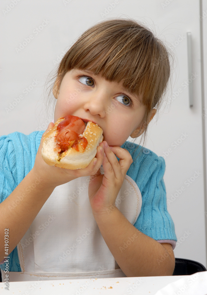 Pequeña niña comiendo perro caliente,hotdog. Pequeña niña comiendo perro caliente,hotdog.