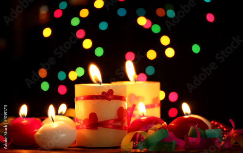 Beautiful candles on wooden table on bright background