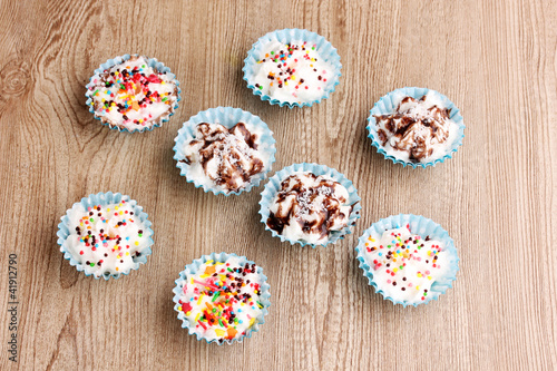 Creamy cupcakes on wooden background