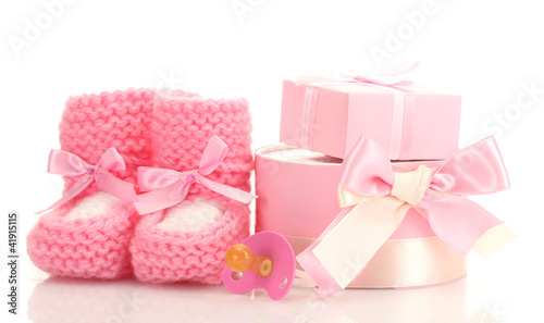 pink baby boots, pacifier and gifts isolated on white