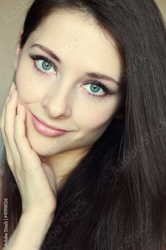 Portrait of beautiful woman touching clean face with green eyes