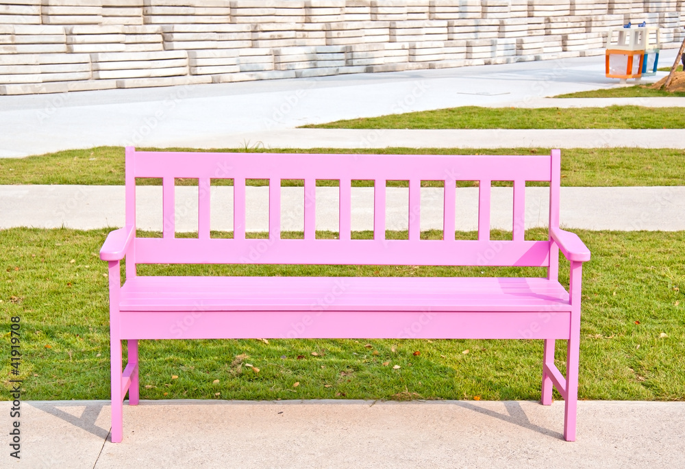 Pink wood chair on the green grass