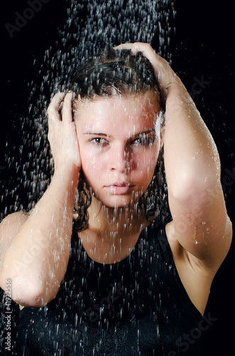 The girl under a shower on the black