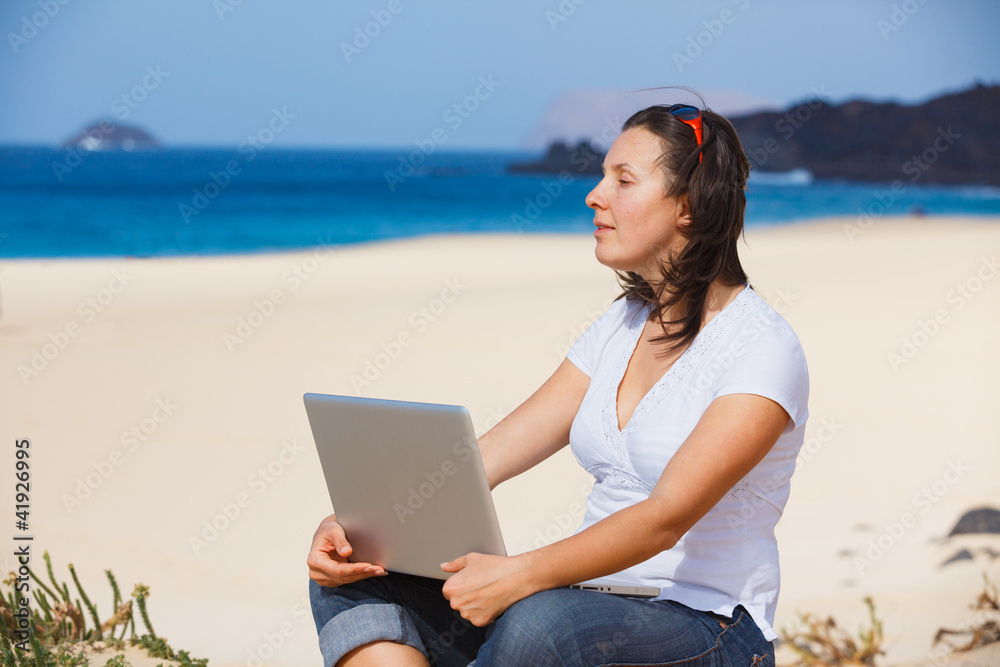 Woman on the beach with laptop computer