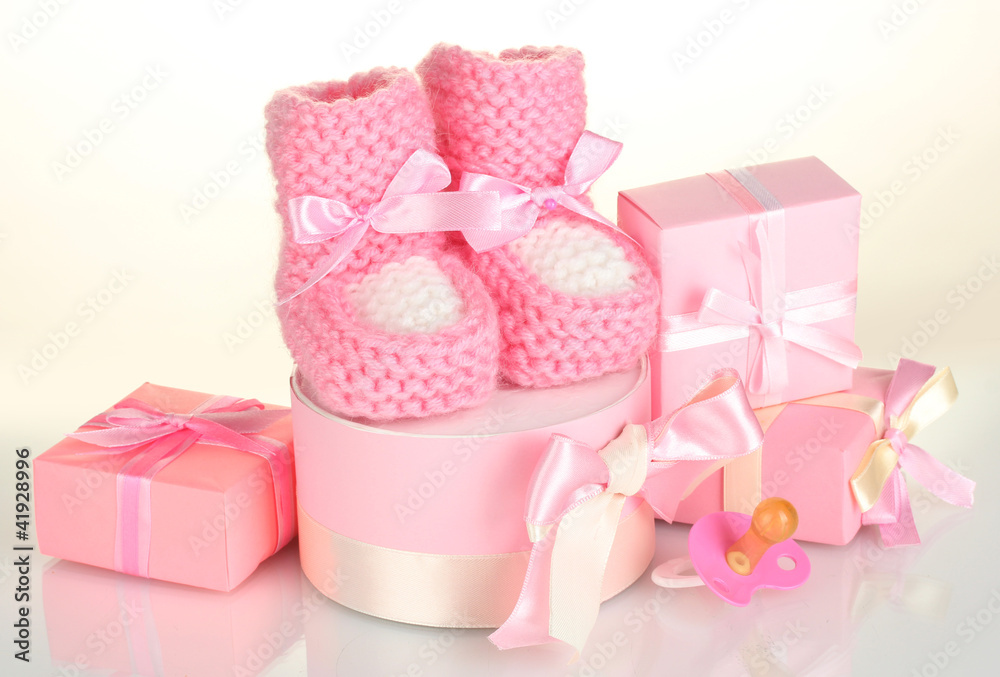 pink baby boots, pacifier and gifts isolated on white pink baby boots, pacifier and gifts isolated on white