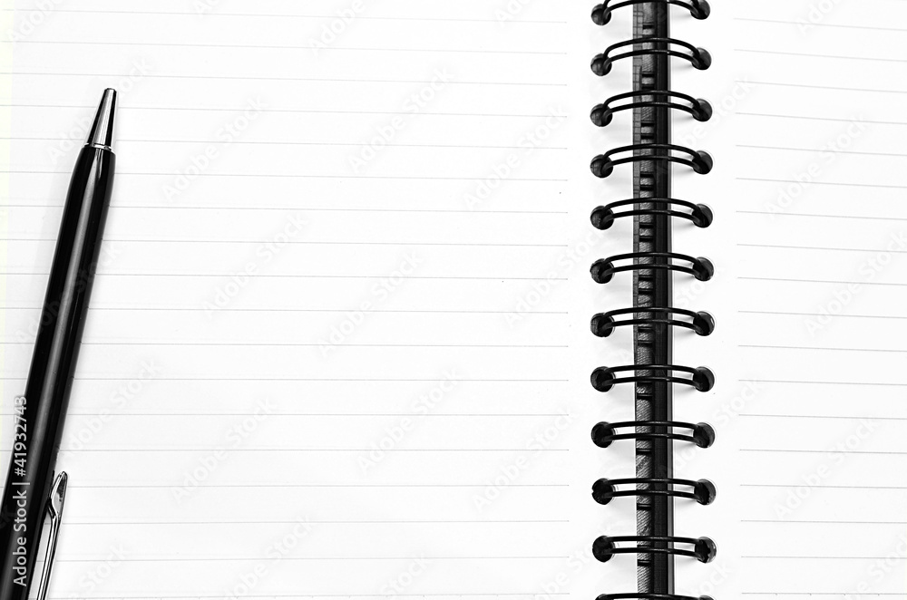 Notebook and pen in composition in black and white Notebook and pen in composition in black and white