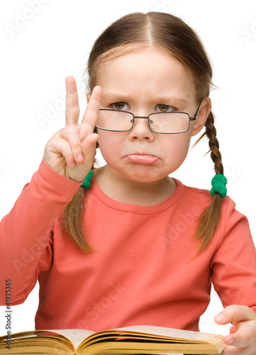 Sad little girl showing  Victory  gesture