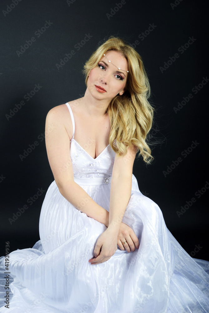 Fototapeta premium beautiful blonde in white gown on gray background