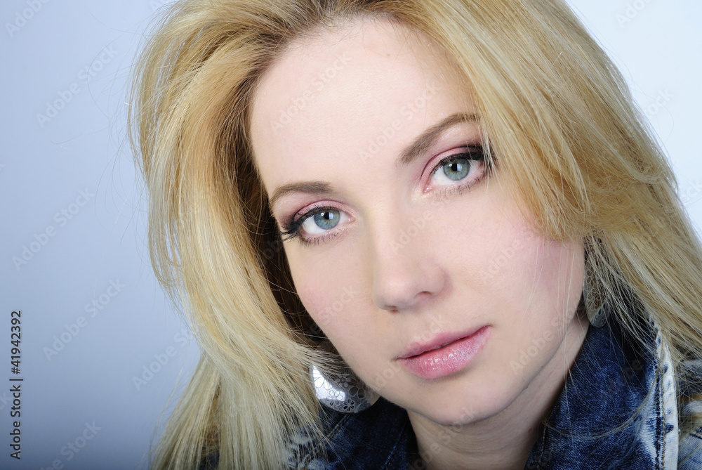 Naklejka premium portrait of the beautiful girl blonde with long hair in jeans su