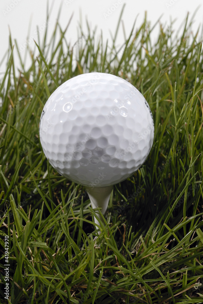 Pelota de golf en el césped, vertical Pelota de golf en el césped, vertical