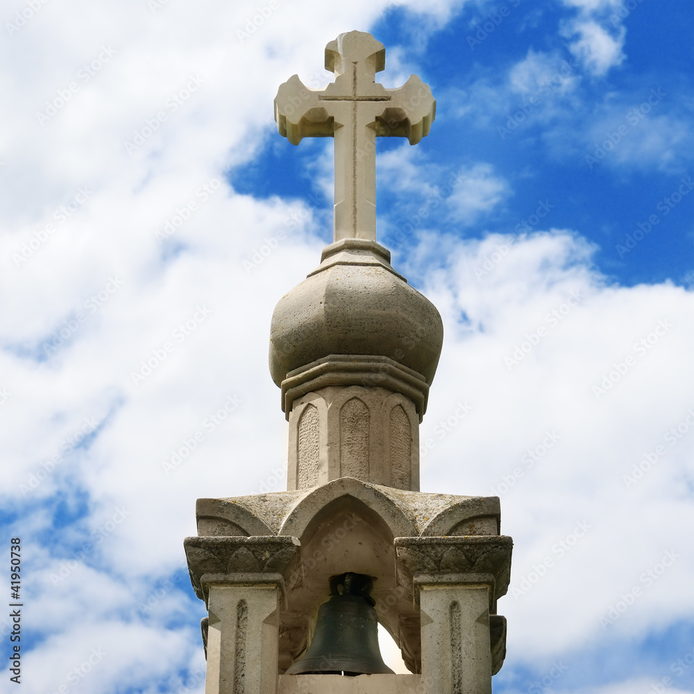 Stone cross on blue sky background