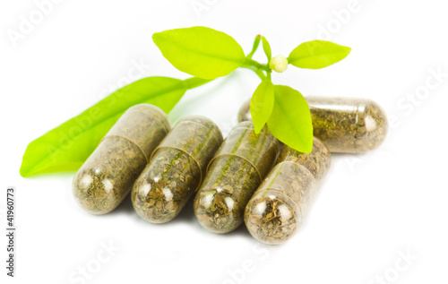 herbal medicine pills with green plant on white background