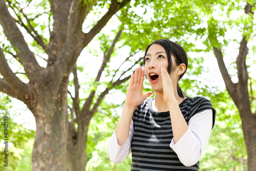 young asian woman cheering in the forest