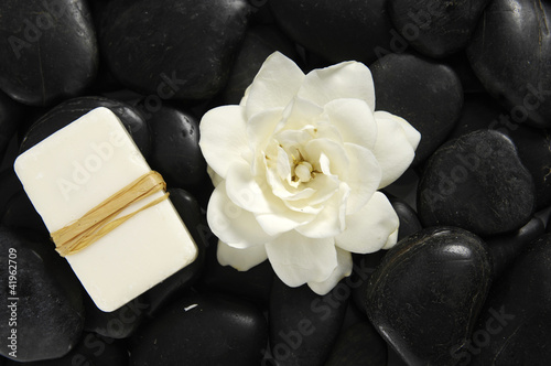 white gardenia flowers and soap on pebbles