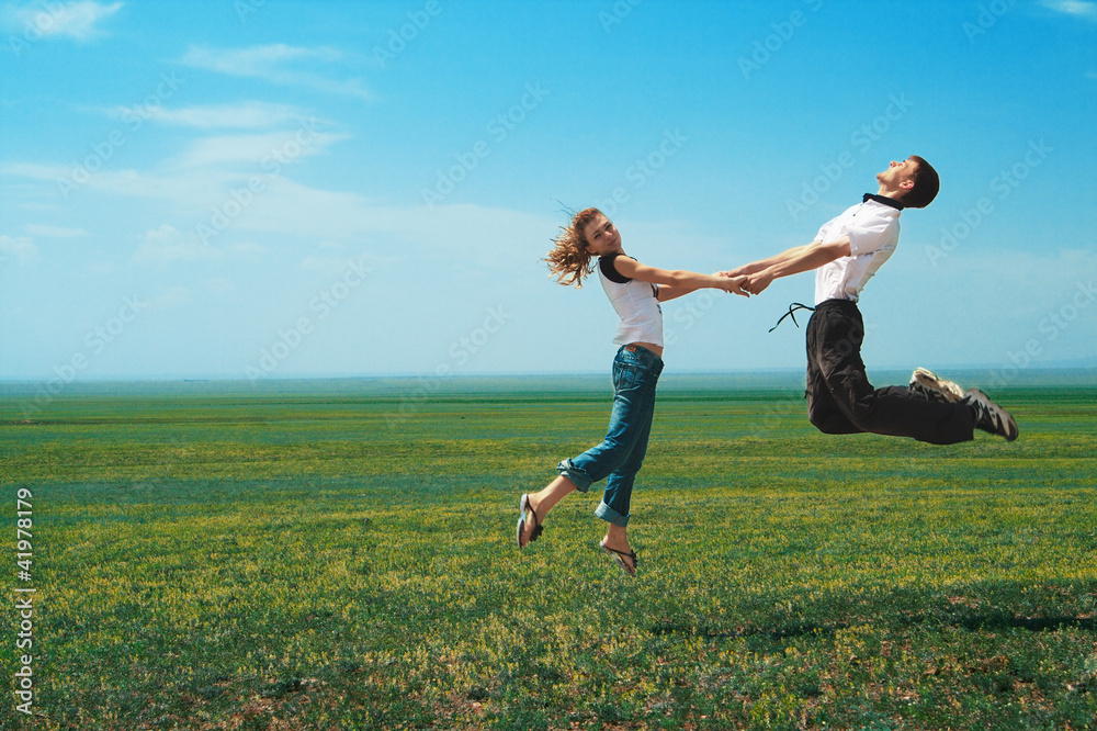 Fun couple in jump on the field Fun couple in jump on the field
