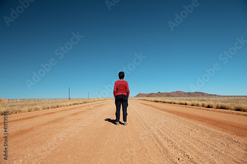 woman front back in the desert road