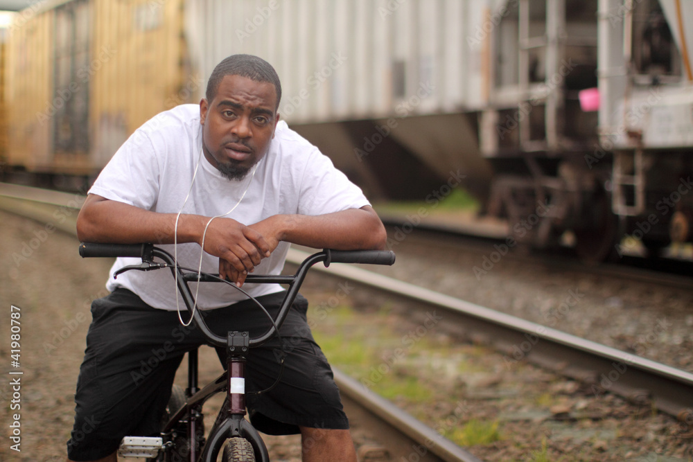 Young black man on a BMX bicycle.