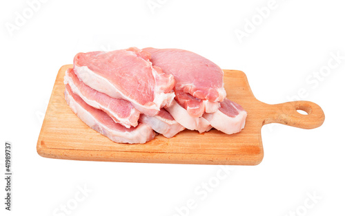 Raw meat steaks on wooden board, isolated on white background