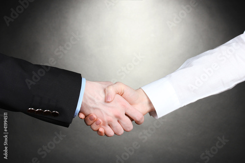 Business handshake on gray background