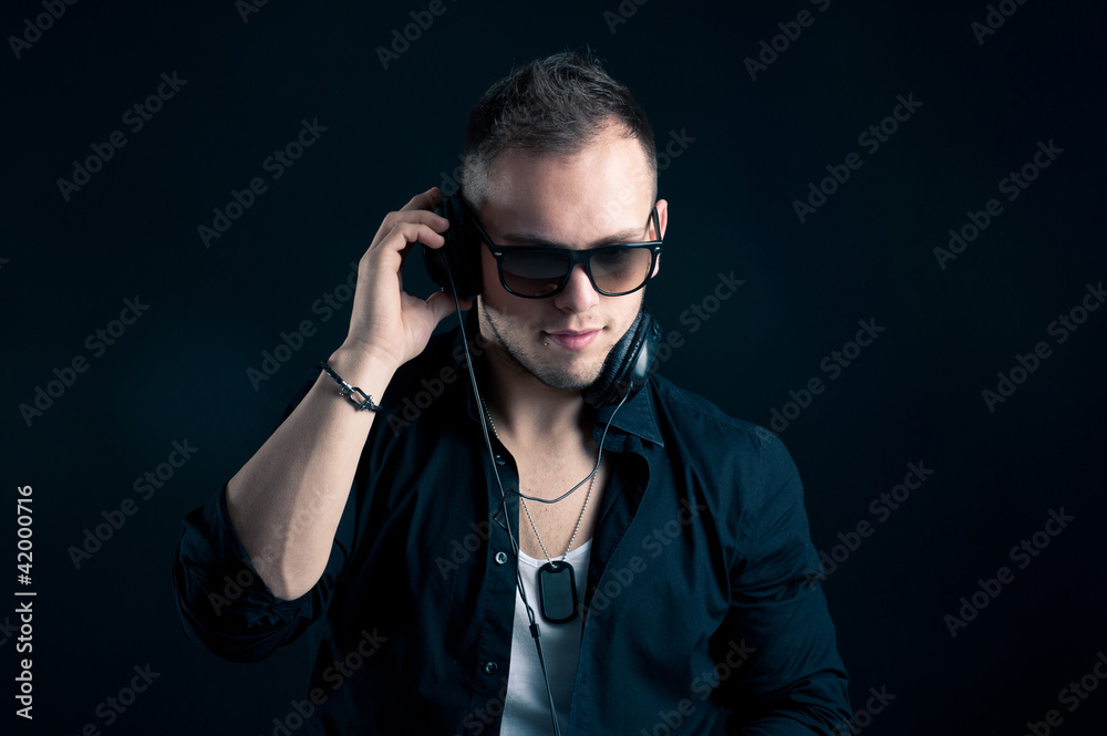 Portrait of man with ear-phones on black background. Portrait of man with ear-phones on black background.