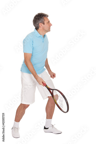 Mature man playing tennis