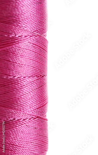 pink bobbin thread isolated on white.