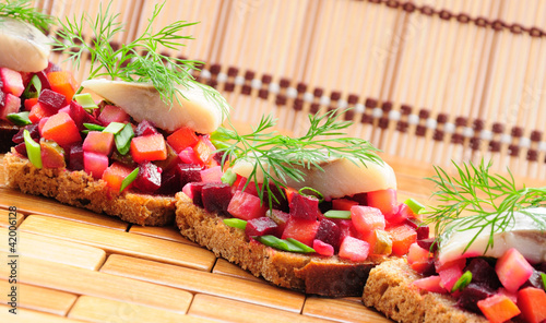 Sandwiches with rye bread, herring and vegetables photo