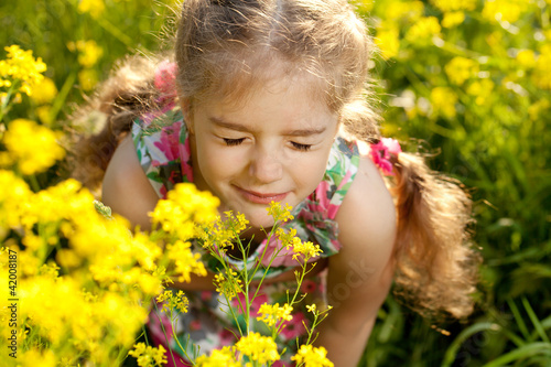 Little blonde girl inhales scent of flowers © dimedrol68