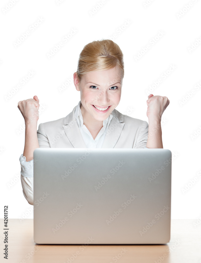 Smiling young businesswoman sitting at a desk with laptop Smiling young businesswoman sitting at a desk with laptop