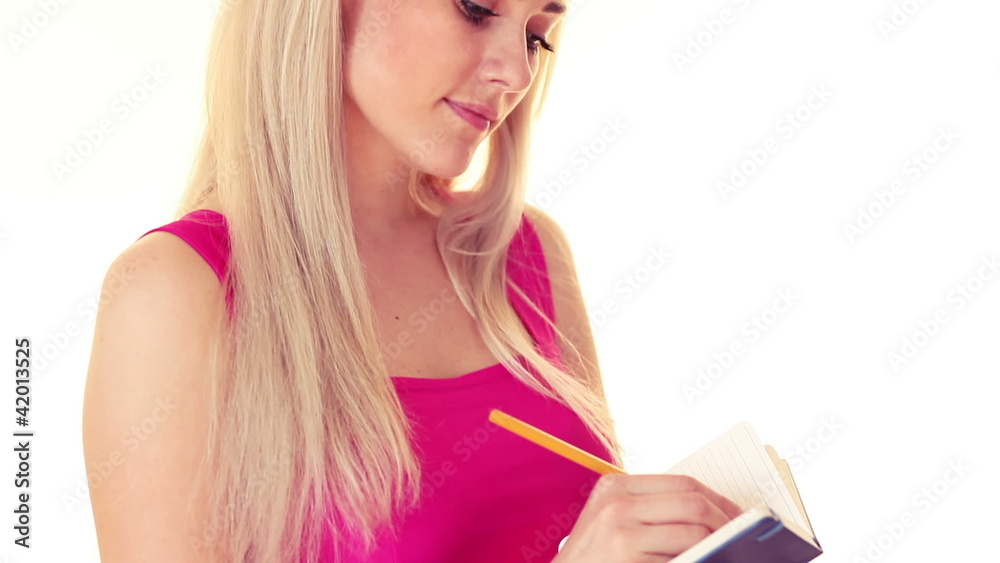 young blonde woman with notepad, write something and smiling young blonde woman with notepad, write something and smiling