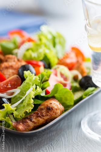 Chicken Salad  glass of water with lemon in the foreground 