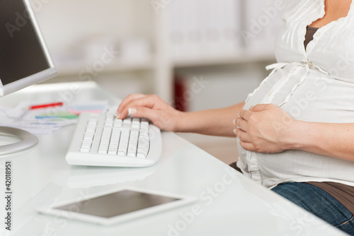 schwangere frau arbeitet im büro